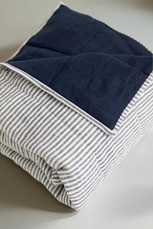 Stonewashed European linen bedding in soft natural tones, styled on a modern bed. #color_navy-stripe
