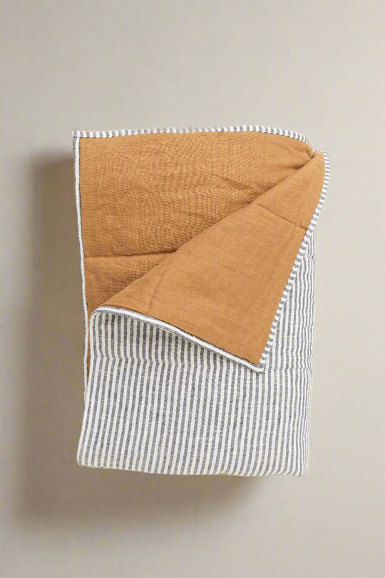 100% European flax linen bedding in soft sage green, folded on bed. King size Linen Quilted Blanket #color_burnt-orange-stripe