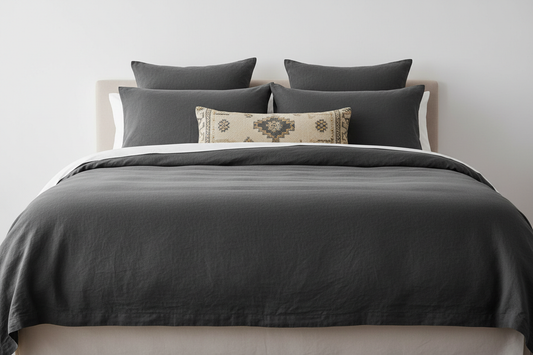 Put the bed against a white wall, no window and remove the plant. remove the white pillow and make the lumbar into a lighter cream turkish patterned lumbar #color_ancient-ashes